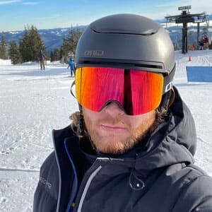Aaron Lovett wearing a ski helmet and goggles on a snowy slope